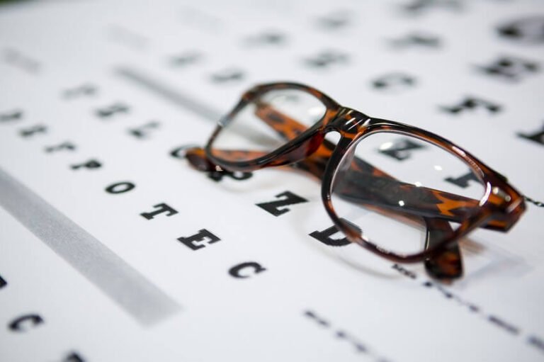 Óculos de armação tartaruga sobre a tabela de optometria, ilustrando lentes multifocais