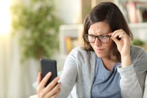 Pessoa com presbiopia lendo com dificuldade